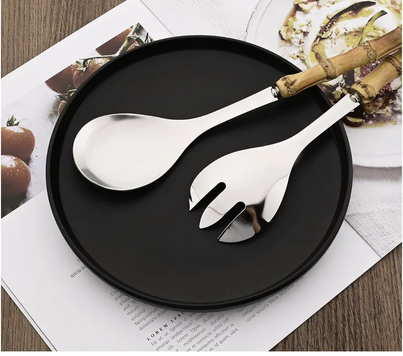 Four-piece stainless serving set with two spoons, two forks, and bamboo handles